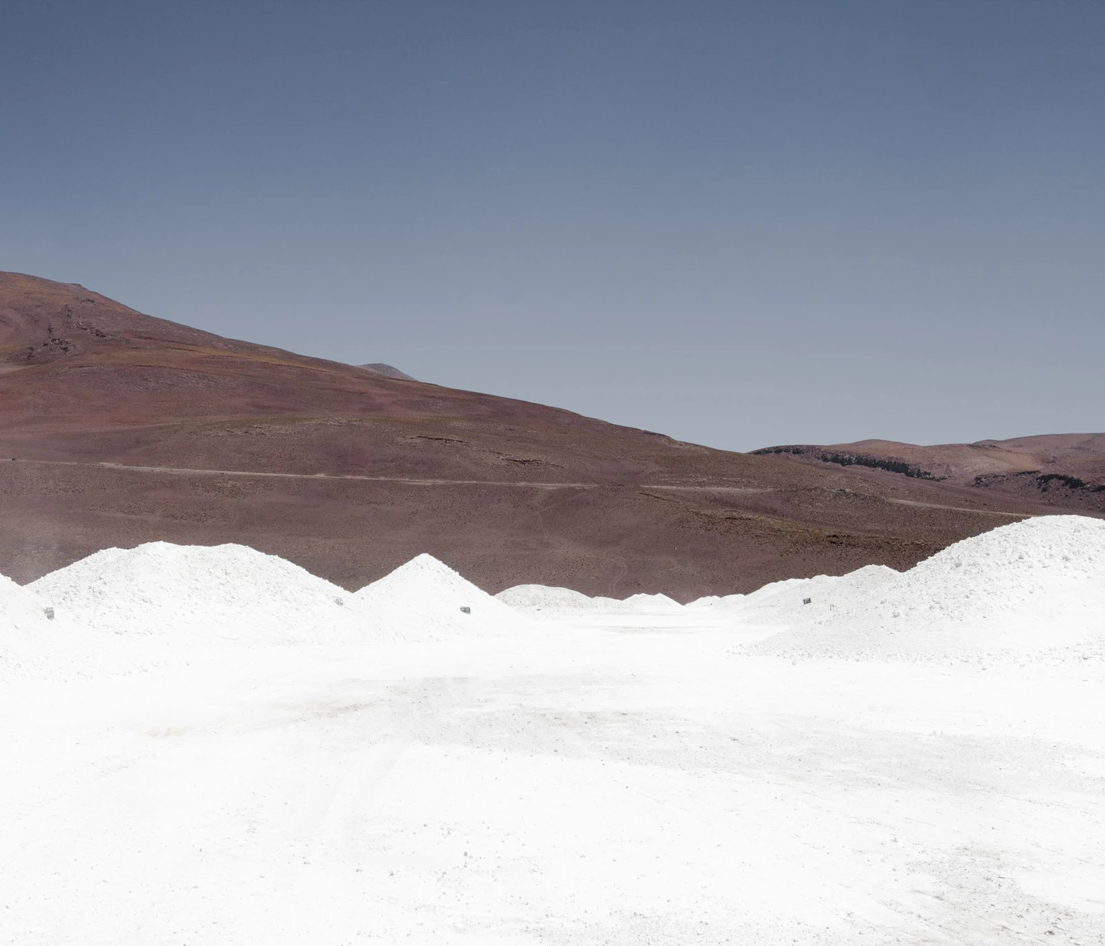 Montículos blancos frente a cerros oscuros.