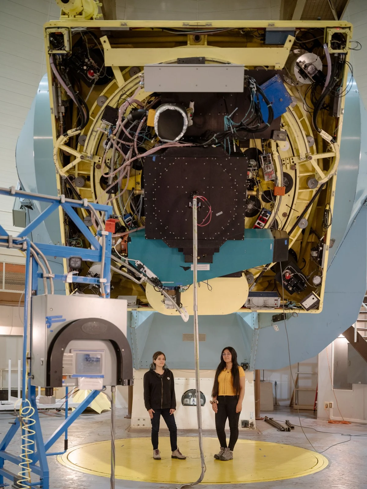 Personas bajo un instrumento astronómico en construcción.