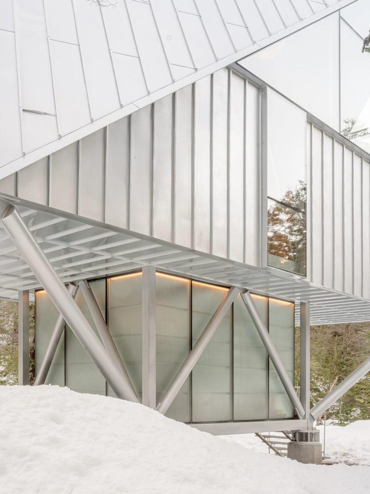 Casa en los Árboles, de Max Núñez Arquitectos: estructura metálica y vidrio sobre un terreno cubierto de nieve.