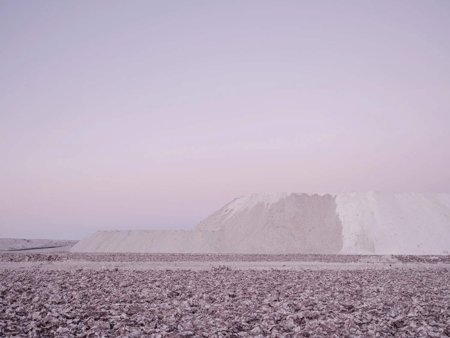Paisaje mineral bajo una luz rosada.